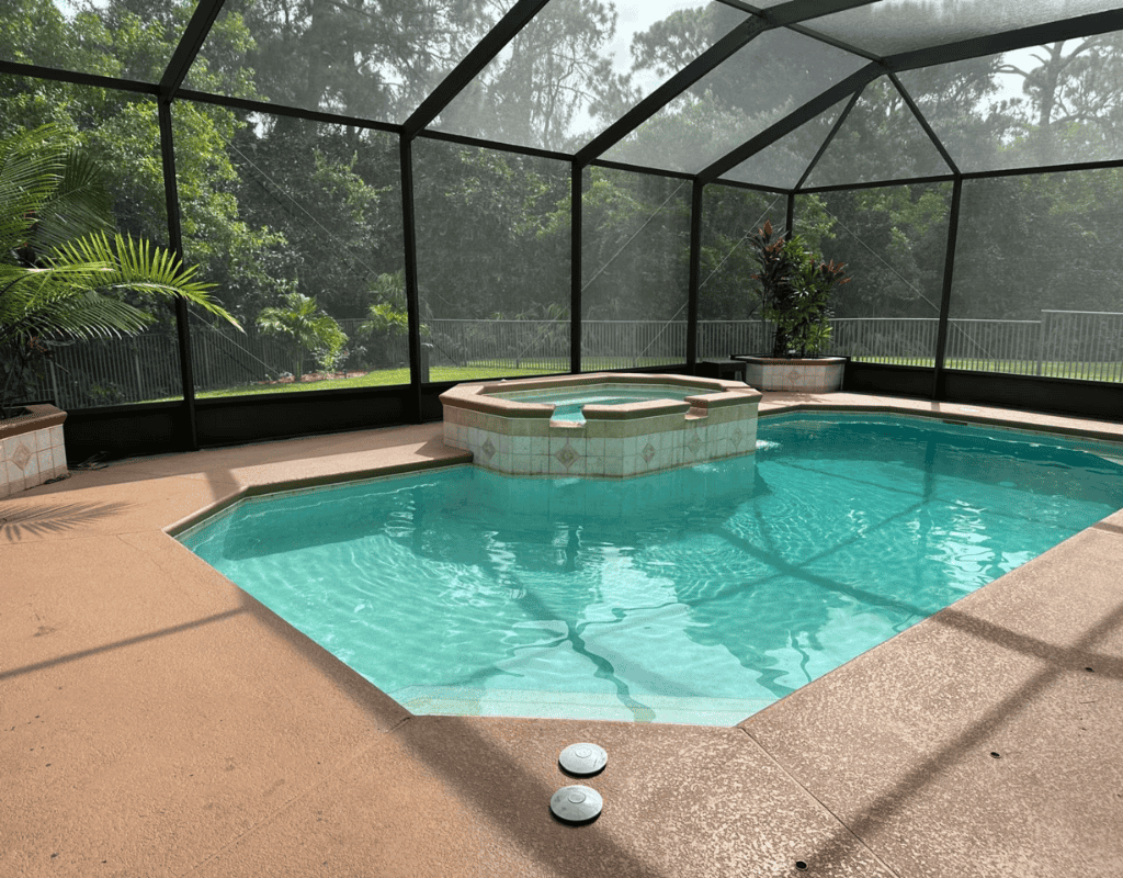 Small screened-in pool and raised spa with worn tile and aging plaster before full renovation by Pools USA in Port St. Lucie, FL.